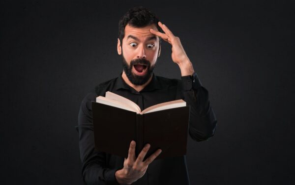 man reading book, surprised - deposit photos