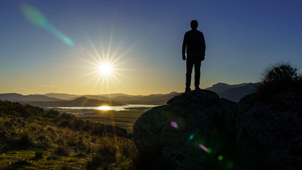man watching the sun rise - deposit photos